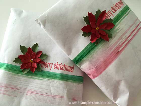 Merry Christmas gift wrapped with poinsettia flowers.